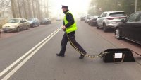 policjant rozkładający kolczatką na jezdni
