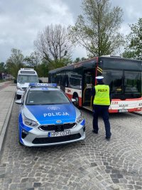 policjant w trakcie kontroli autobusów