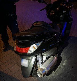 Zdjęcie przedstawia kontrolowany motocykl, obok stoi policjant.