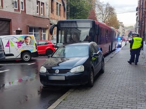 Zdjęcie przedstawia nieprawidłowo zaparkowany pojazd oraz policjantów